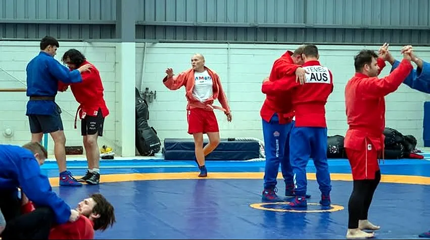 SAMBO athletes practising standing grips during a national competition warm-up
